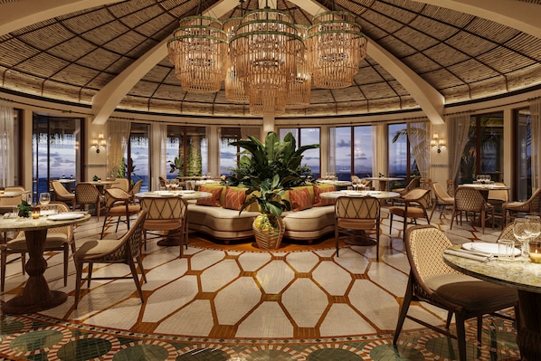 A spacious dining area with high ceilings, large windows, and a central seating area with a plant.