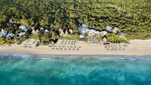 An aerial view of a beach resort with multiple bungalow-style accommodations, a sandy beach, and clear turquoise waters. - Maroma, A Belmond Hotel, Riviera Maya (Playa del Carmen)