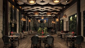 A restaurant with wooden tables and chairs, hanging pendant lights, and a geometric ceiling design. - Sheraton Amman Al Nabil Hotel (Amman)