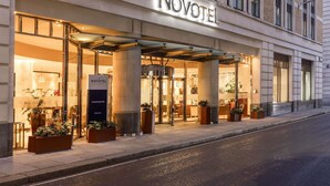 The exterior of Novotel Tower Bridge hotel with a modern facade, large windows, and a welcoming entrance.