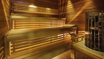 Una sauna con bancos de madera y una pared de piedra.