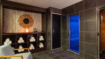 Casa de banho moderna com um espelho grande, um porta-toalhas, uma cabine de duche com iluminação azul e uma porta de madeira.