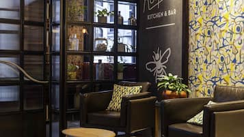 A cozy interior with leather sofas, a wooden table, and a glass partition with shelves.