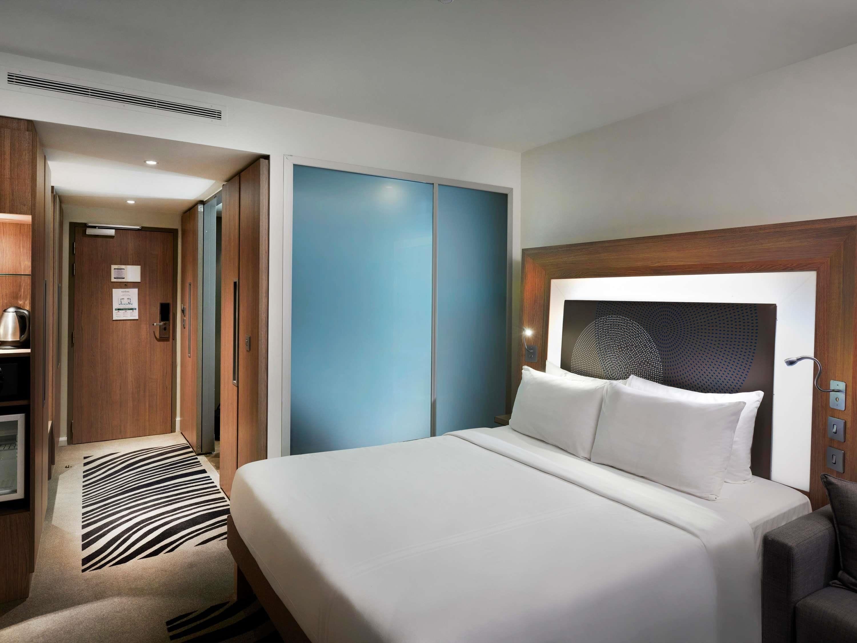 Ein Hotelzimmer mit Bett, Schreibtisch, Kleiderschrank und Bad.