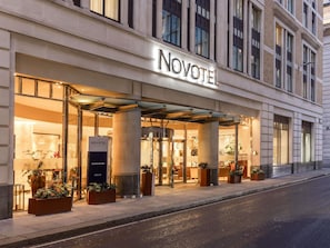 Das Äußere des Novotel Tower Bridge Hotels mit moderner Fassade, großen Fenstern und einladendem Eingang.