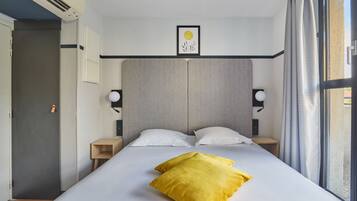 Ein modernes Hotelzimmer mit einem großen Bett, zwei Nachttischen, einer Kopfteil und einem Fenster mit Vorhängen.