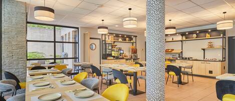A modern restaurant with multiple dining areas, a central pillar with a unique pattern, and a visible kitchen area.