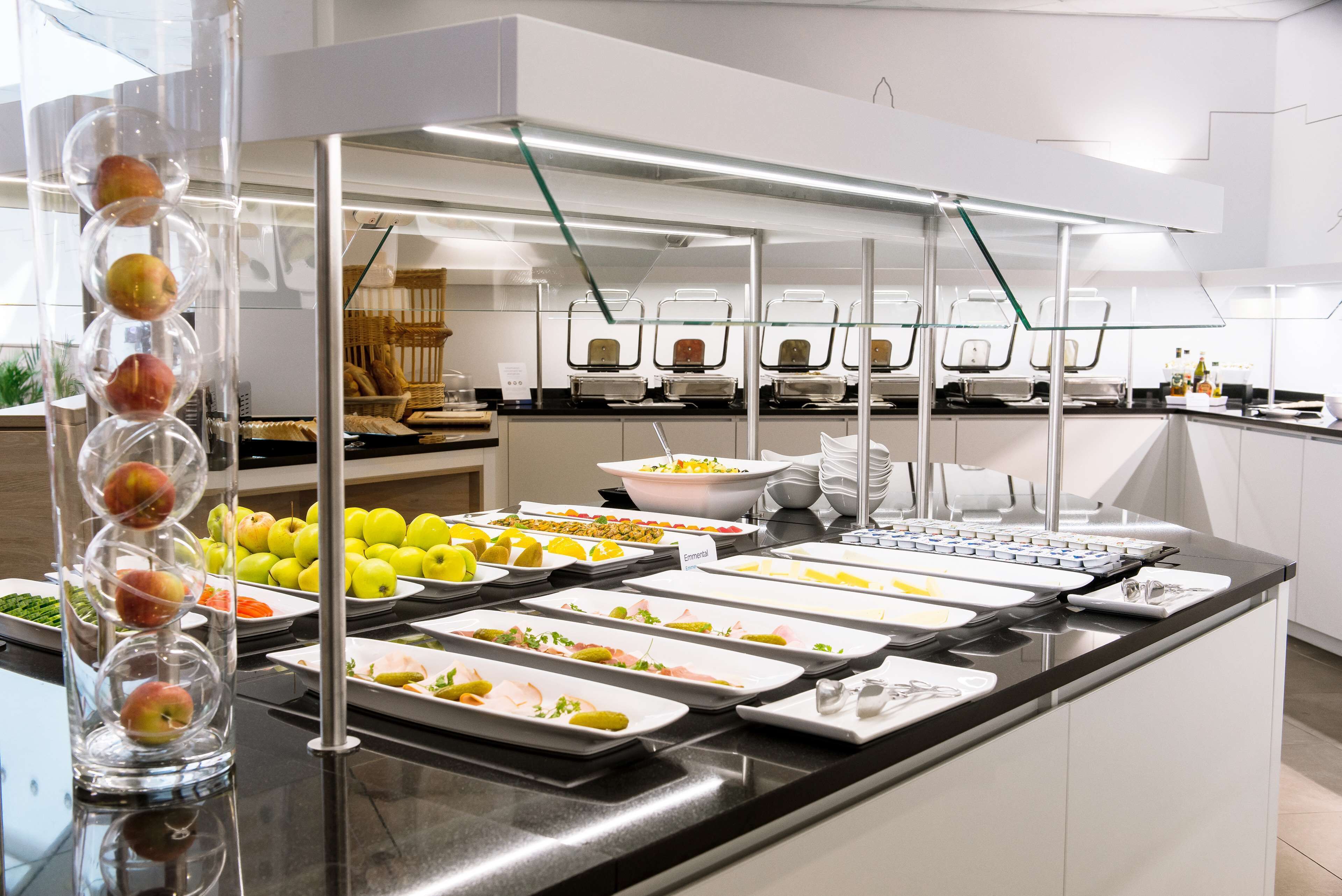 A buffet setup with various food items and a fruit display.