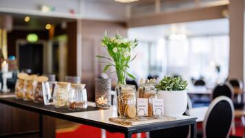 A long table with jars of snacks, a potted plant, and a sign indicating organic and digestible options.
