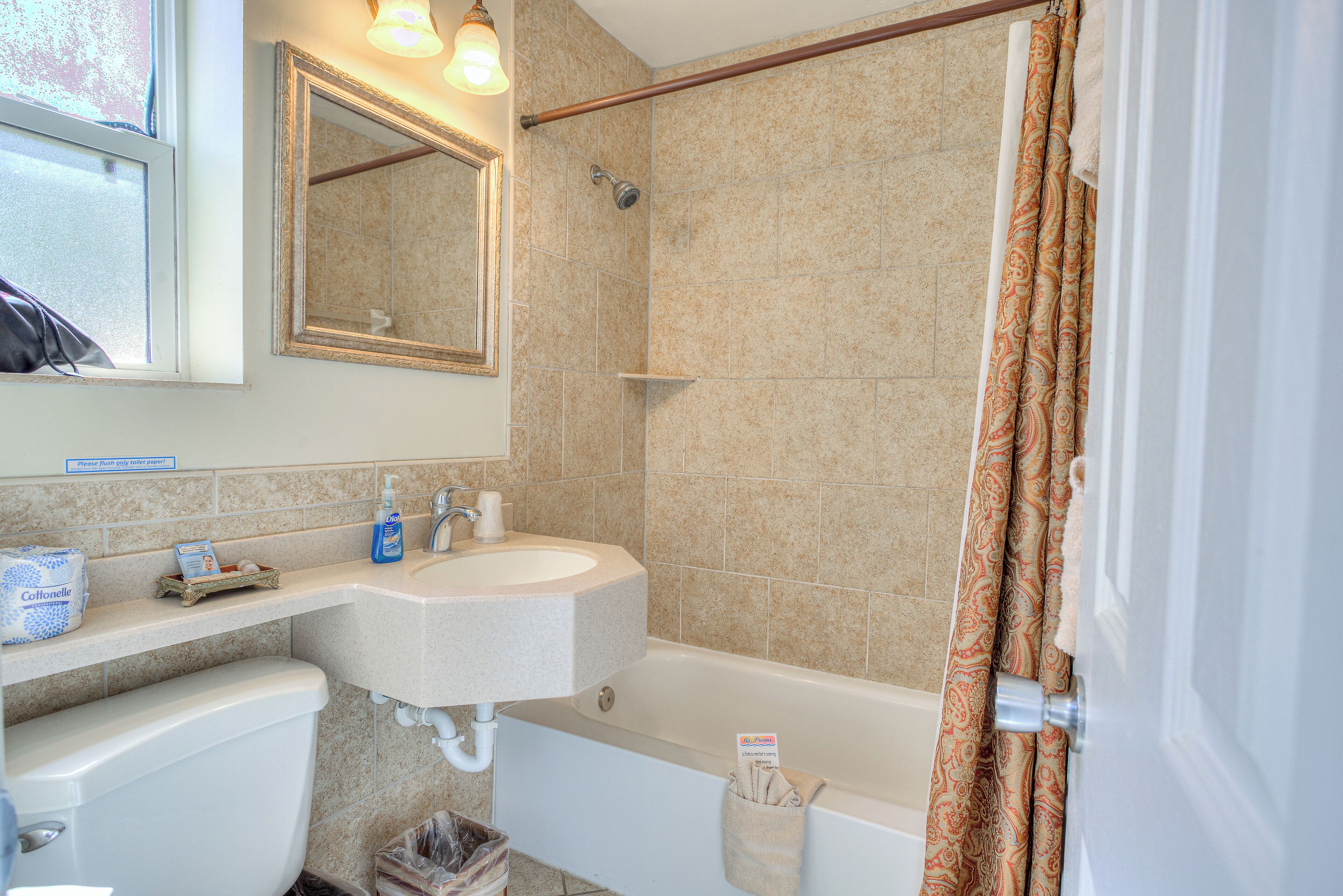 Un baño con lavamanos, espejo, ducha e inodoro.