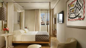 A bedroom with a bed, bedside table, chair, and a painting on the wall.
