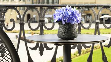 Un balcon avec une table ronde et un vase de fleurs.
