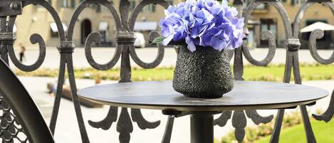 Un balcón con una mesa redonda y un florero.