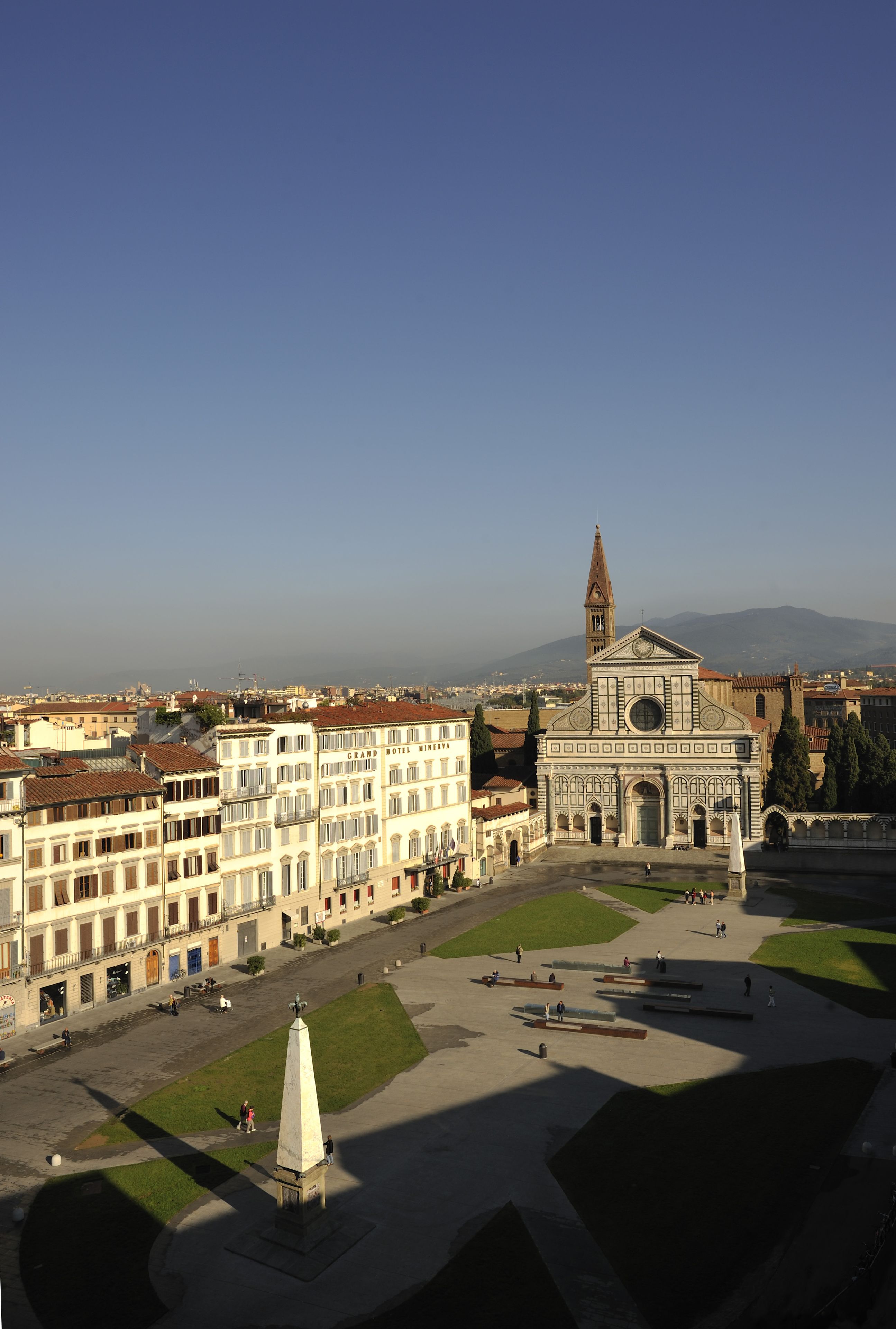 A historic square with a prominent church featuring a tall bell tower, surrounded by classical architecture.