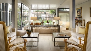 Un salón amplio con un gran ventanal, dos sofás, una mesa de centro y elementos decorativos.