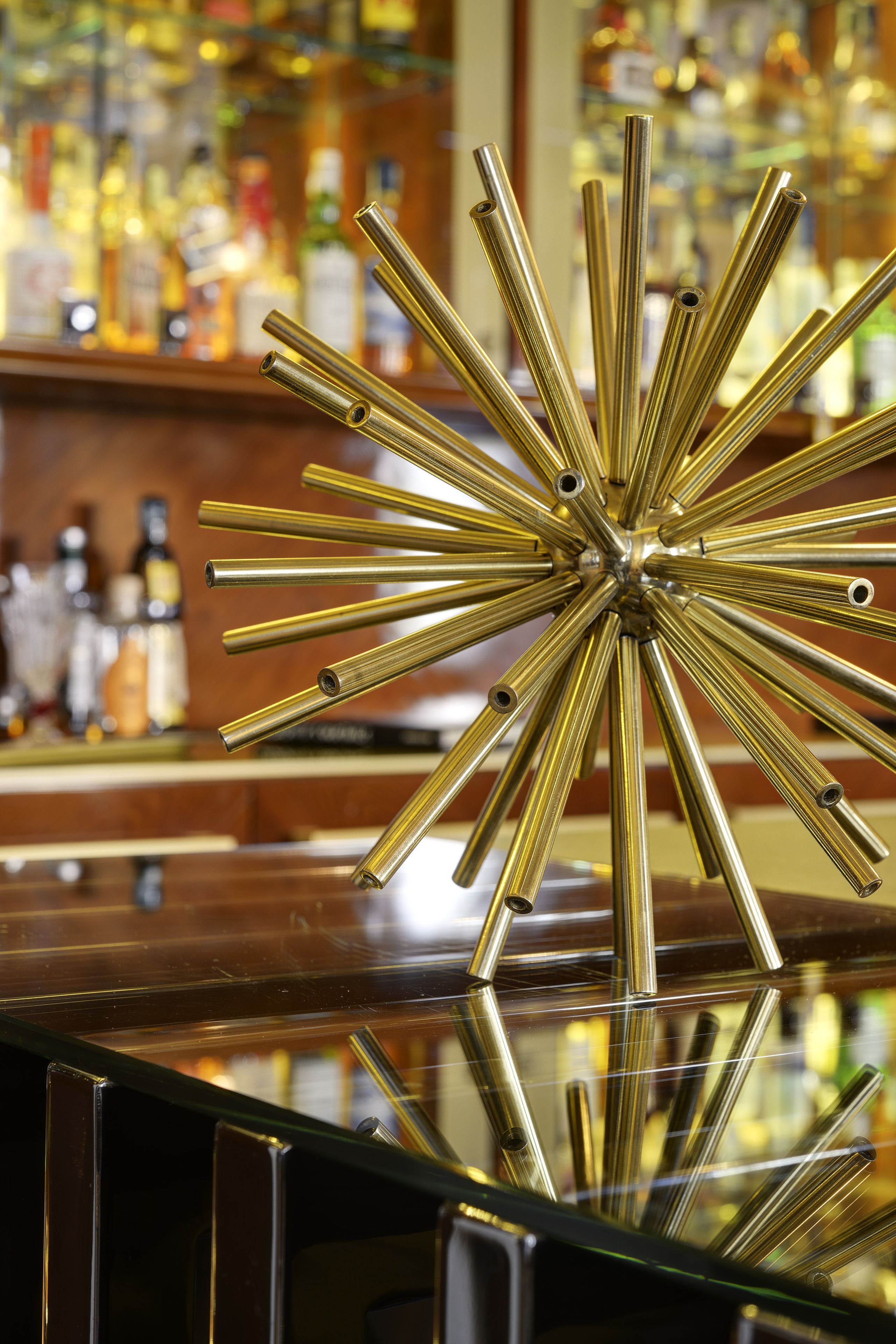 A bar with a reflective surface and a decorative metal piece in the center.