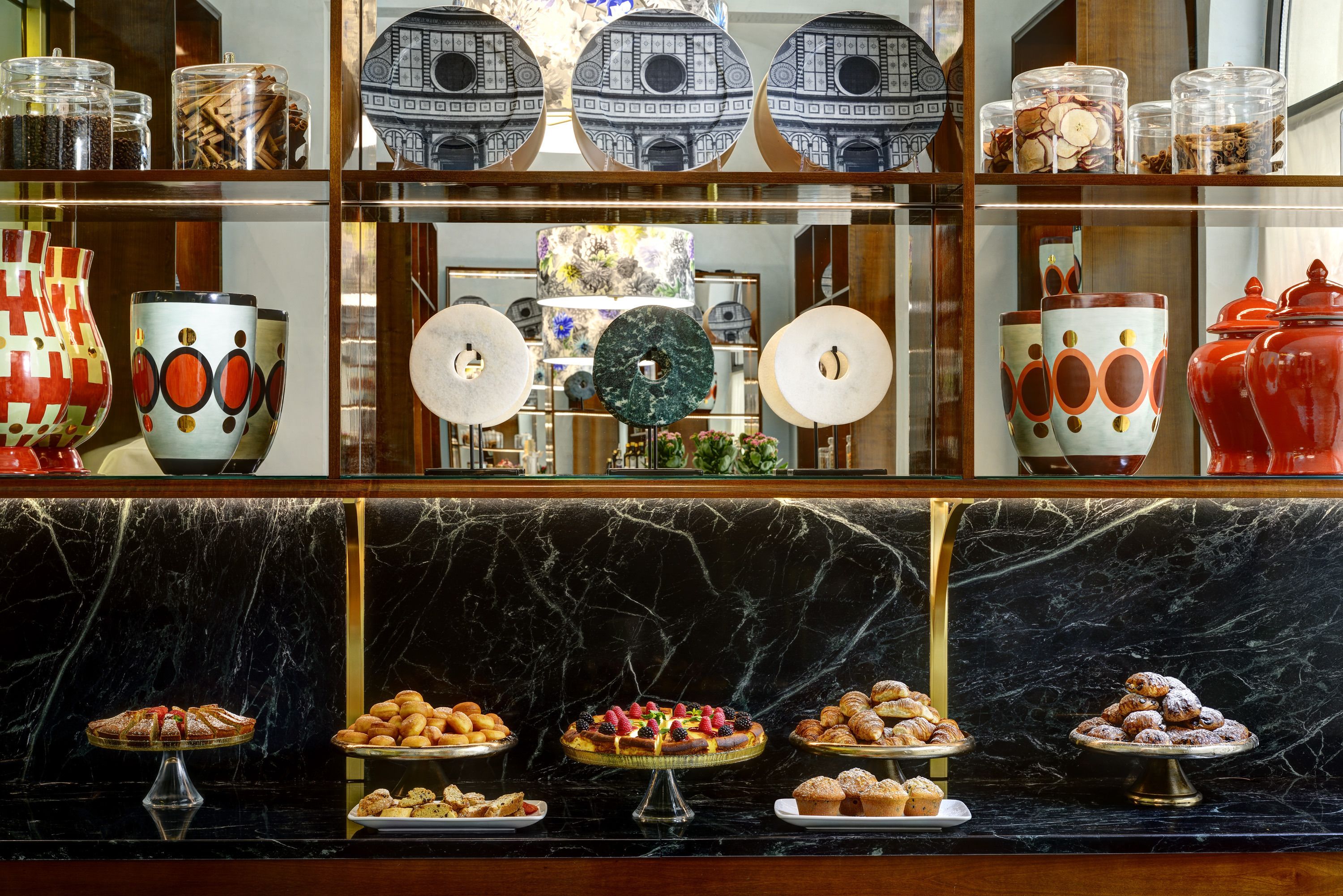 A buffet area with various food items and decorative vases.
