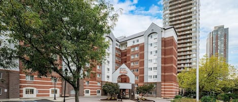 A hotel with a brick facade, a central entrance, and a flagpole.