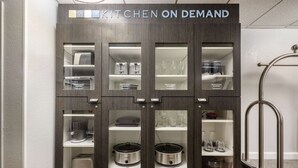 A kitchen cabinet with multiple compartments, including shelves for kitchenware and appliances. - Sonesta Simply Suites Jersey City (Jersey City)