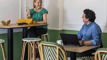 A room with a table, chairs, a laptop, and a smartphone.