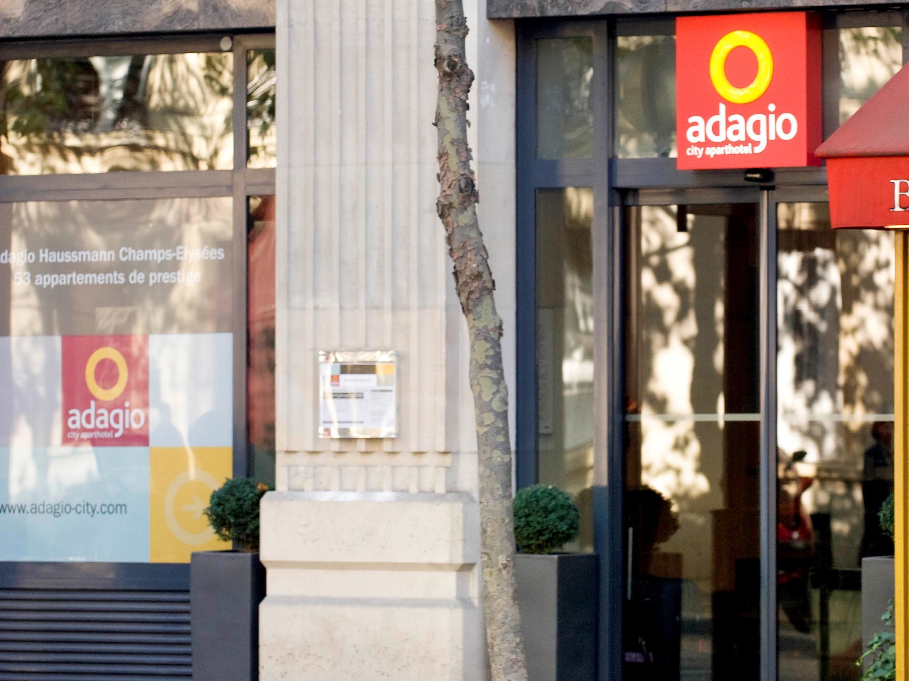 La façade de l’hôtel Adagio City Apartment présente une grande fenêtre sur laquelle est affiché le nom de l’hôtel et son adresse web.