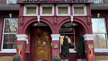 A red brick building with a sign reading 'Garden View Hotel' above the entrance.