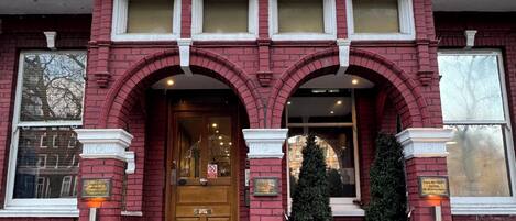 A red brick building with a sign reading 'Garden View Hotel' above the entrance.