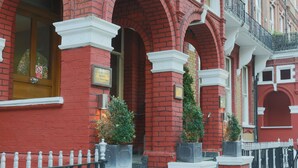 A red brick building with the sign "Garden View Hotel" and a balcony with black railings. - Garden View Hotel (London)