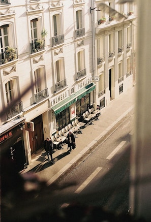 A street view of a building with a coffee shop named 'NUMERO 10 PIGALLE' and outdoor seating. - Le Pigalle, a Member of Design Hotels (Paris)