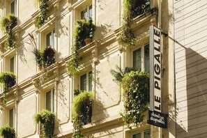 A building facade with multiple windows, some with plants. A sign reads 'LE PIGALLE' with additional text 'chambres disponibles' indicating available rooms. - Le Pigalle, a Member of Design Hotels (Paris)