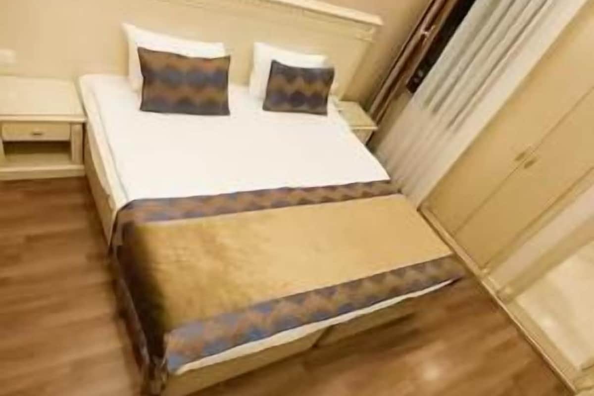 Ein Hotelzimmer mit Bett, Nachttisch und Kleiderschrank.