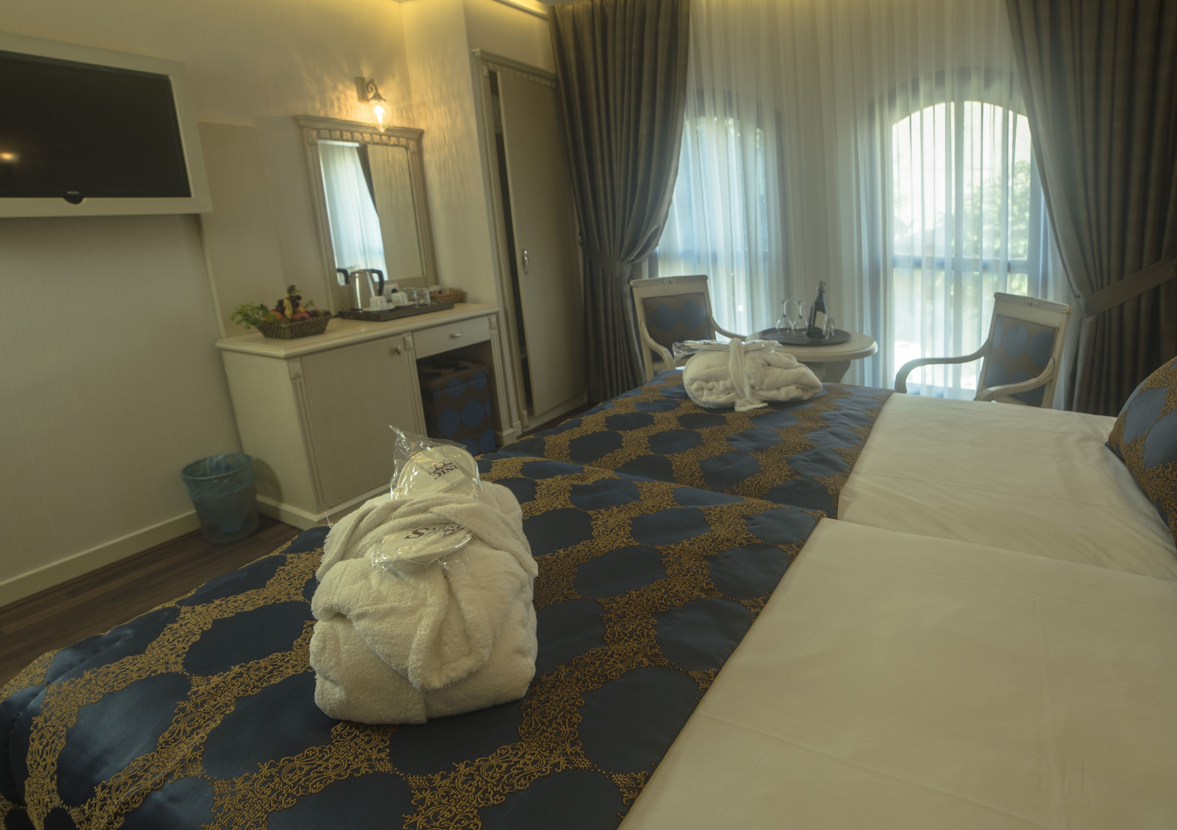 Una habitación de hotel con una cama, un escritorio, una silla y un televisor.