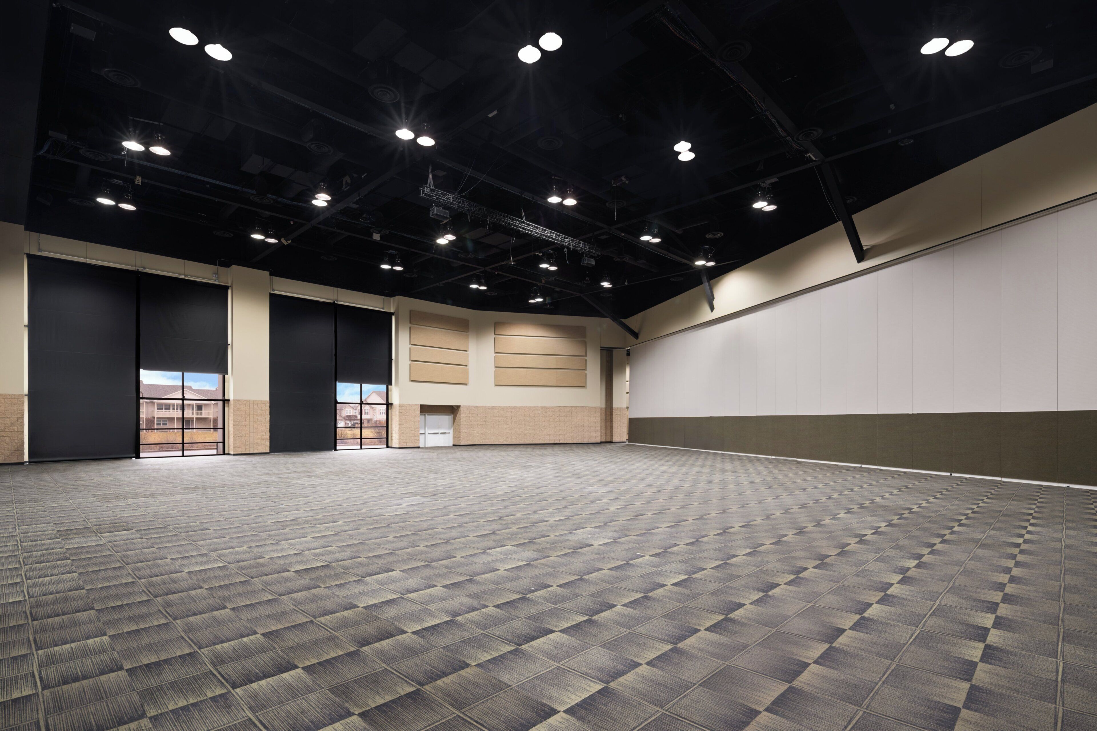 A large, empty indoor space with a patterned floor, high ceilings, and multiple ceiling lights.