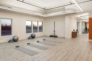 A spacious room with large windows, exercise equipment, and a wooden floor. - EVEN Hotel Chicago Tinley Park-Conv Ctr by IHG (Tinley Park)