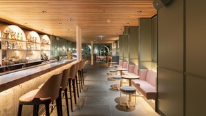 A bar area with a long counter, multiple stools, and a seating area with round tables and sofas. - St. James' Court, A Taj Hotel, London (London)
