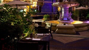 A historic building with ornate architecture, a central fountain, and outdoor seating areas. - St. James' Court, A Taj Hotel, London (London)