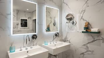 A modern bathroom with two sinks, a large mirror, and a towel rack.