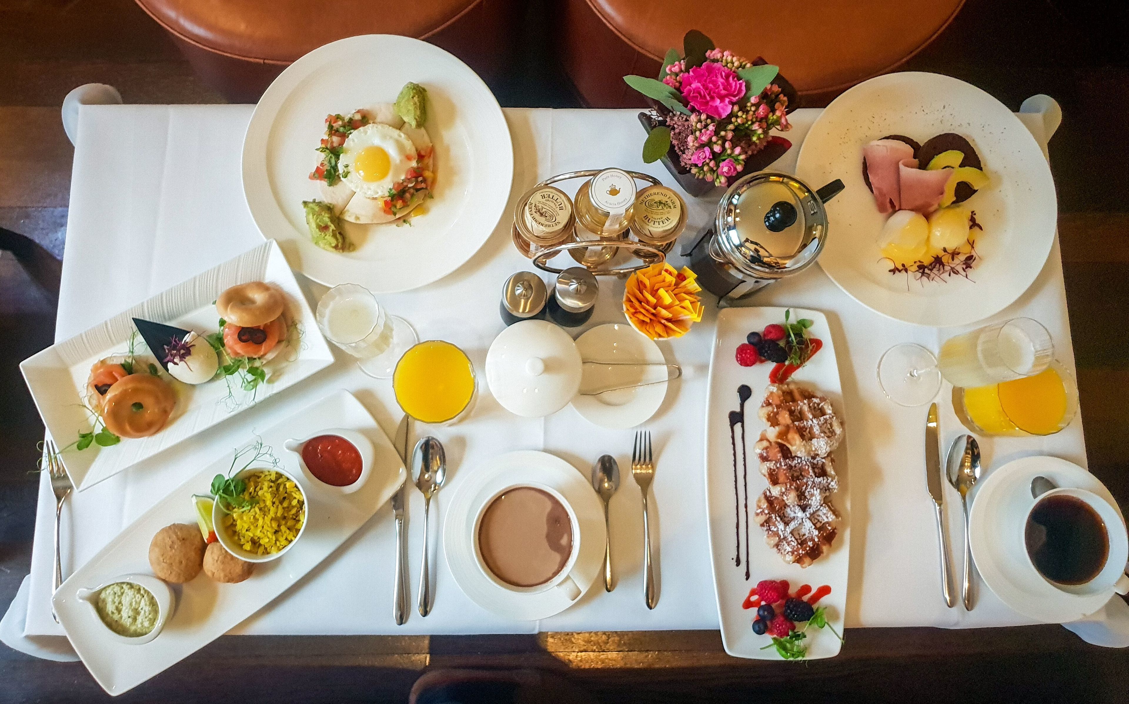 A breakfast buffet with various dishes and beverages.