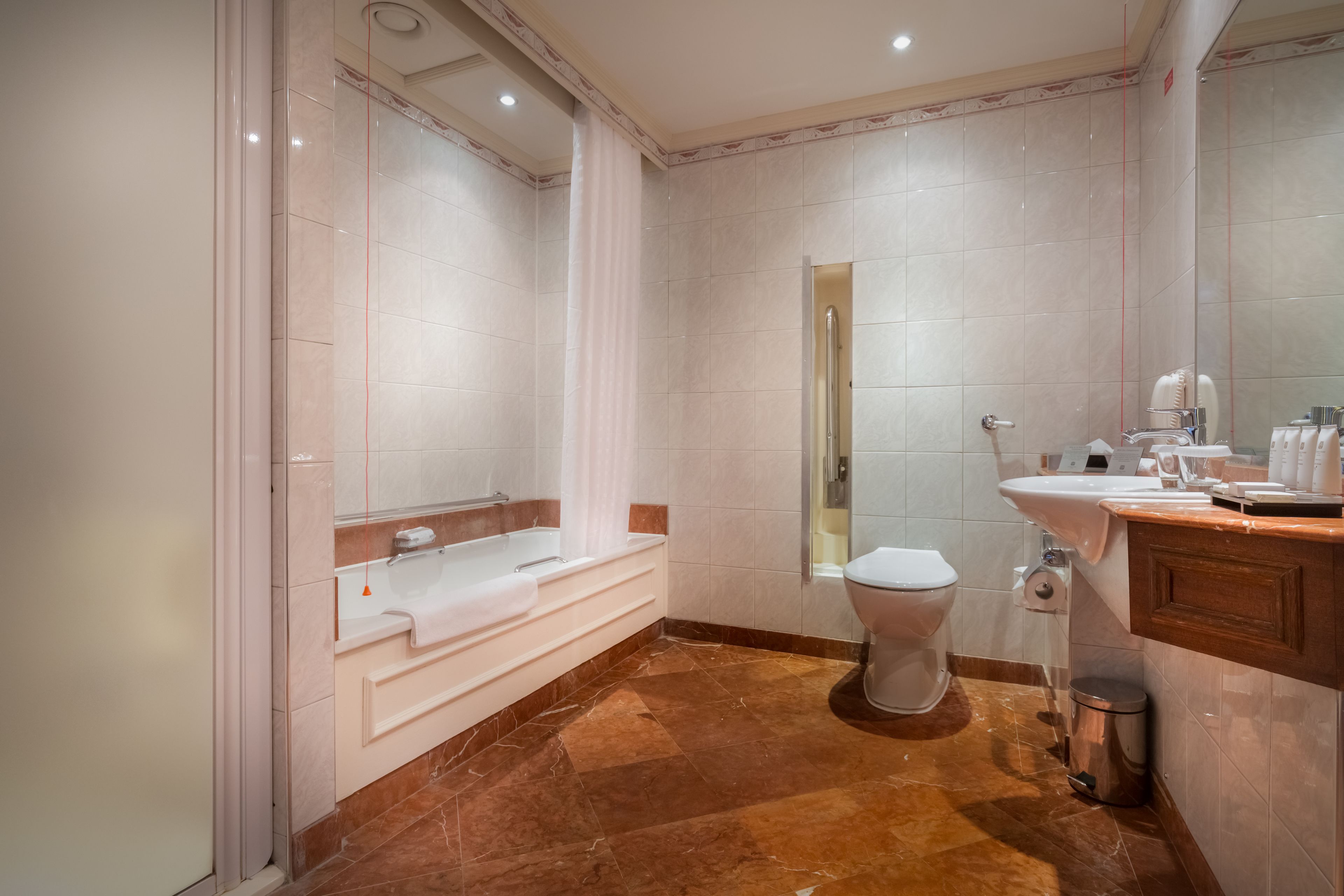A modern bathroom with a bathtub, toilet, sink, and a mirror.