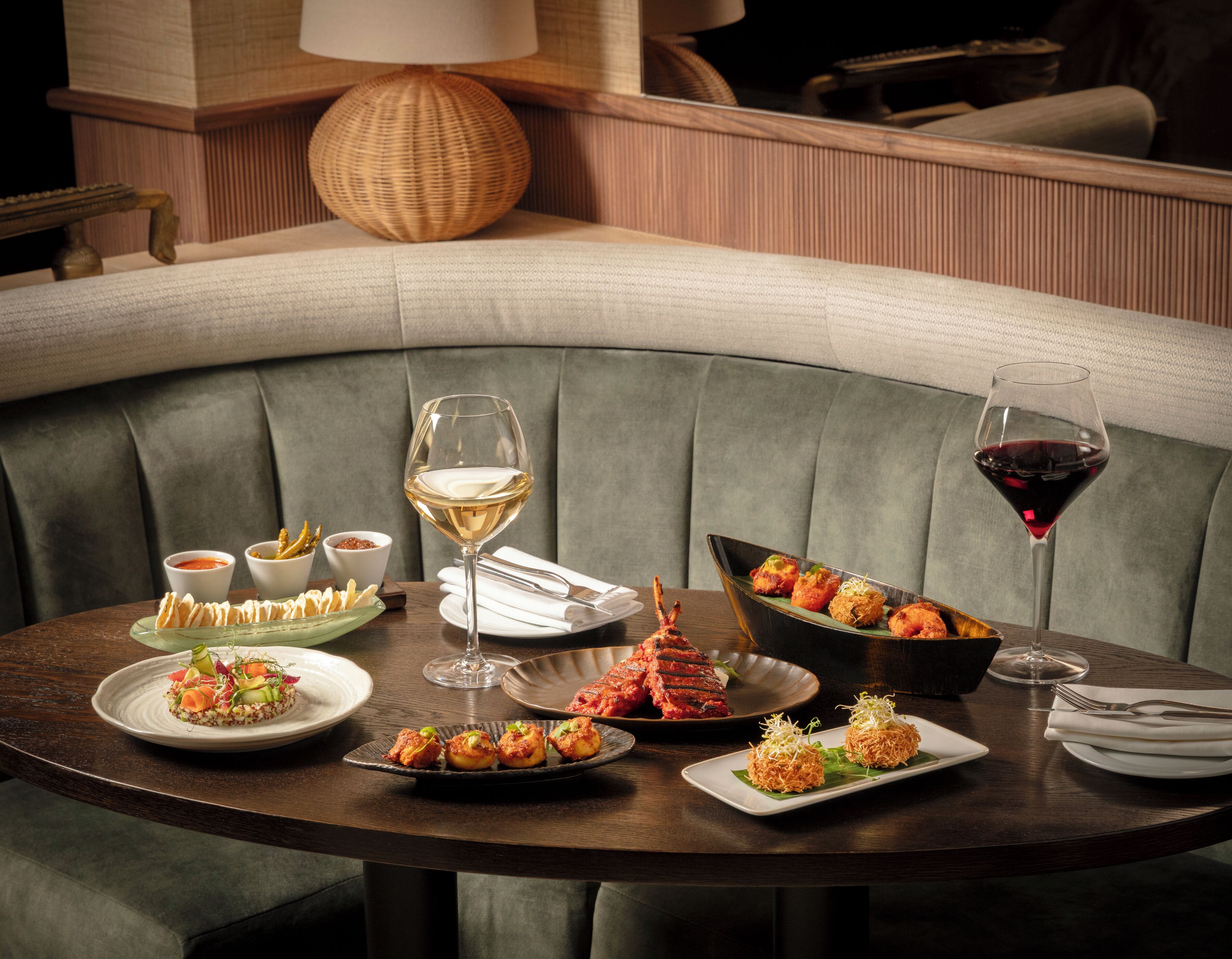 A dining table set with various dishes, wine glasses, and cutlery, indicating a restaurant setting.
