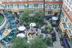 An indoor courtyard with a central fountain, surrounded by seating areas and greenery.