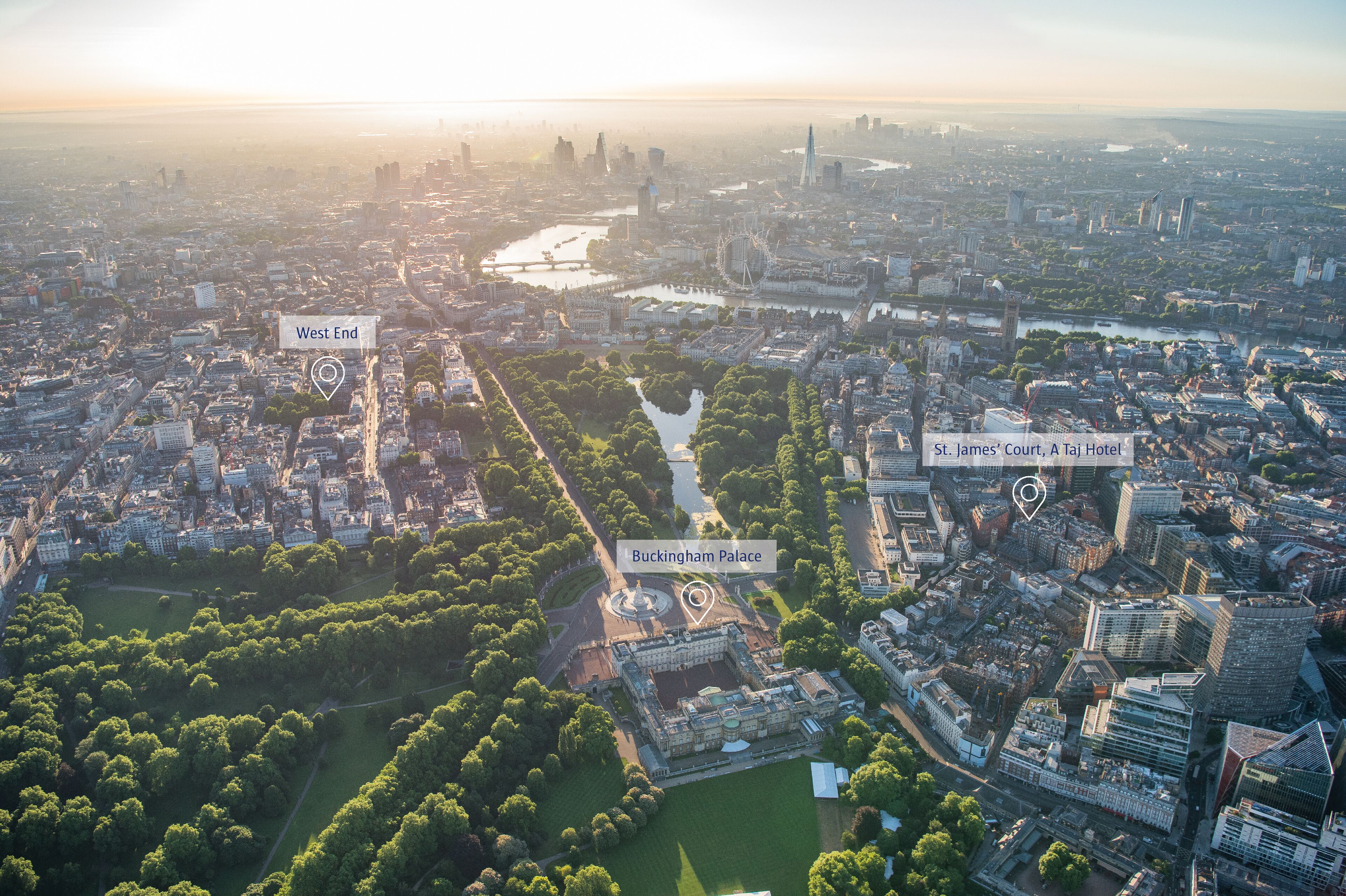 An aerial view of a cityscape with Buckingham Palace, St. James' Court, and the West End area.