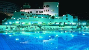 Una piscina al aire libre de temporada, sombrillas