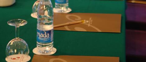 Una larga mesa con botellas de agua, vasos y tarjetas de nombre.