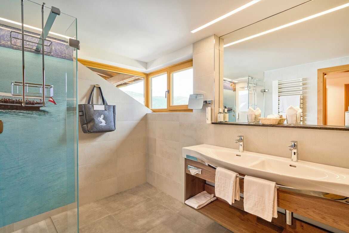 A modern bathroom with a glass-enclosed shower, a large mirror, and a wooden vanity.