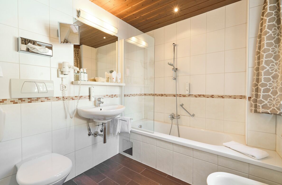 A bathroom with a toilet, sink, and bathtub.