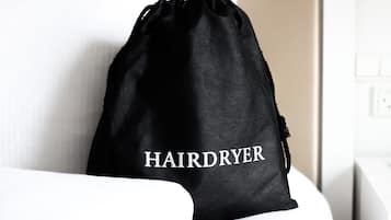 Una bolsa negra con cordón de ajuste con la etiqueta 'HAIRDRYER' sobre una superficie blanca.