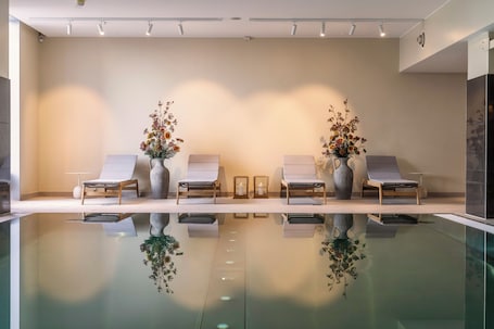 Una piscina techada, sillones reclinables de piscina. Clarion Hotel Copenhagen Airport