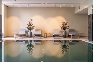 Una piscina techada, sillones reclinables de piscina