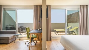 A hotel room with a bed, a desk, a chair, and a balcony with outdoor furniture. - ARTIEM Madrid Hotel (Madrid)